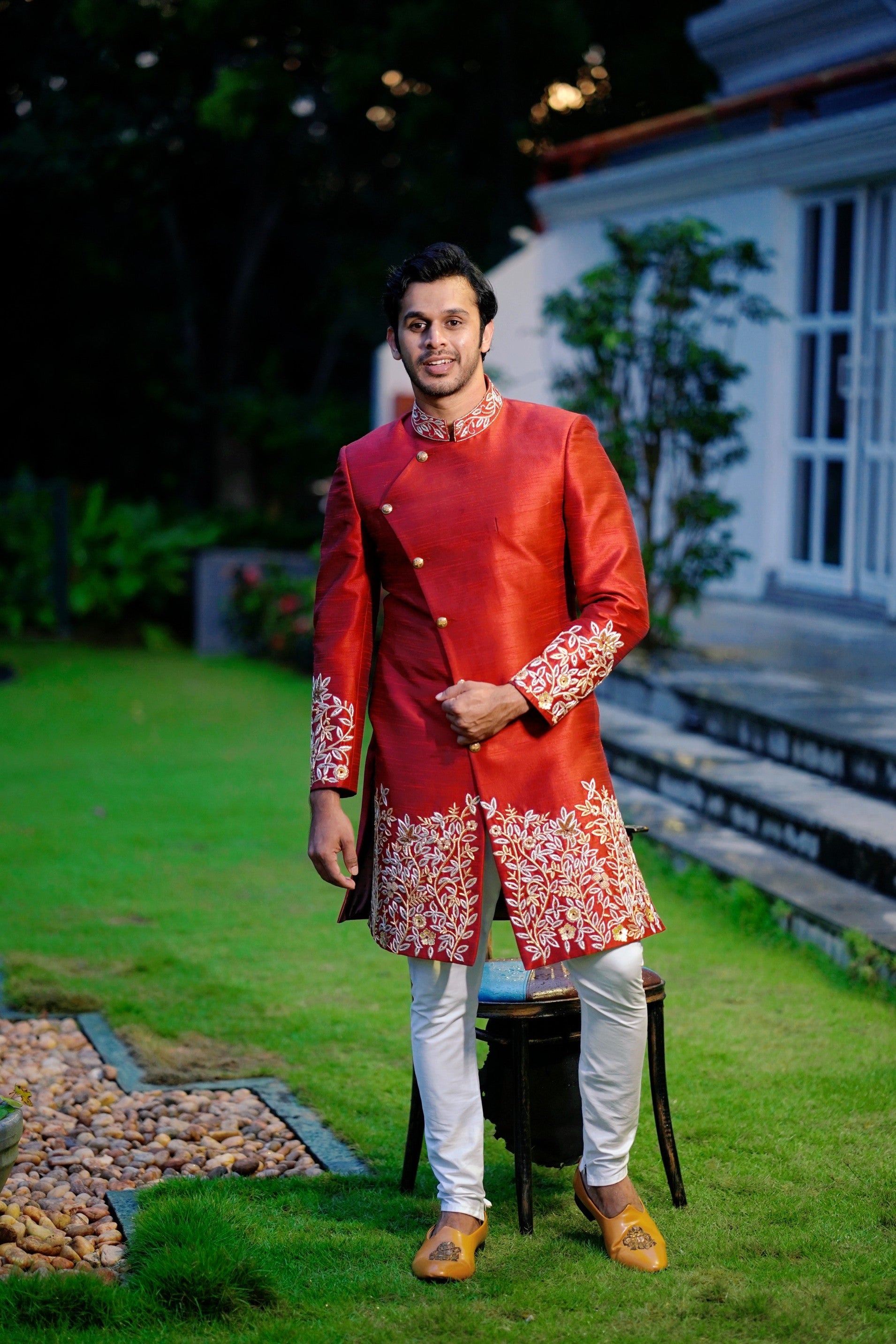 Ruby Red Side Open Indo Western Slim Achkan Suit with Golden Floral Handwork Detailing paired with White Narrow Pants