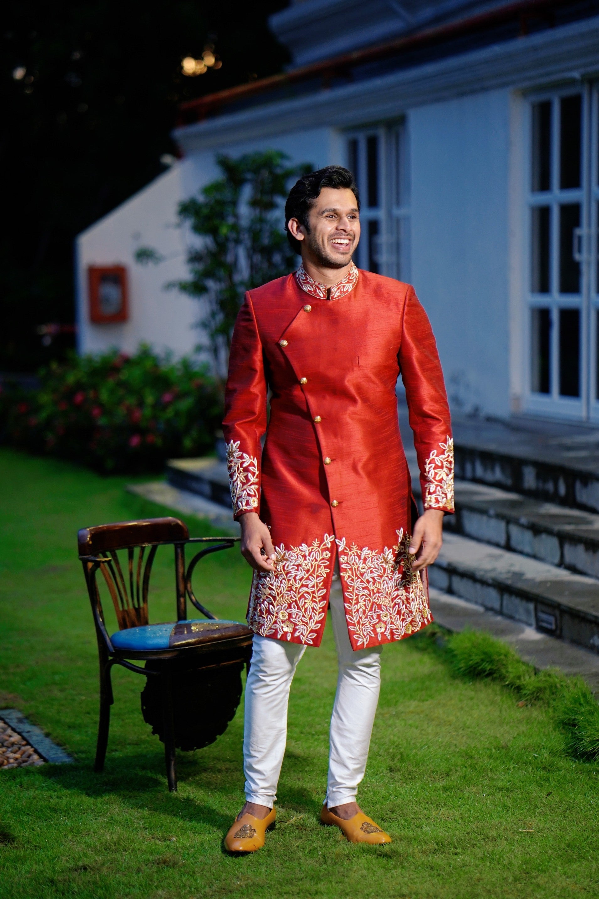 Ruby Red Side Open Indo Western Slim Achkan Suit with Golden Floral Handwork Detailing paired with White Narrow Pants