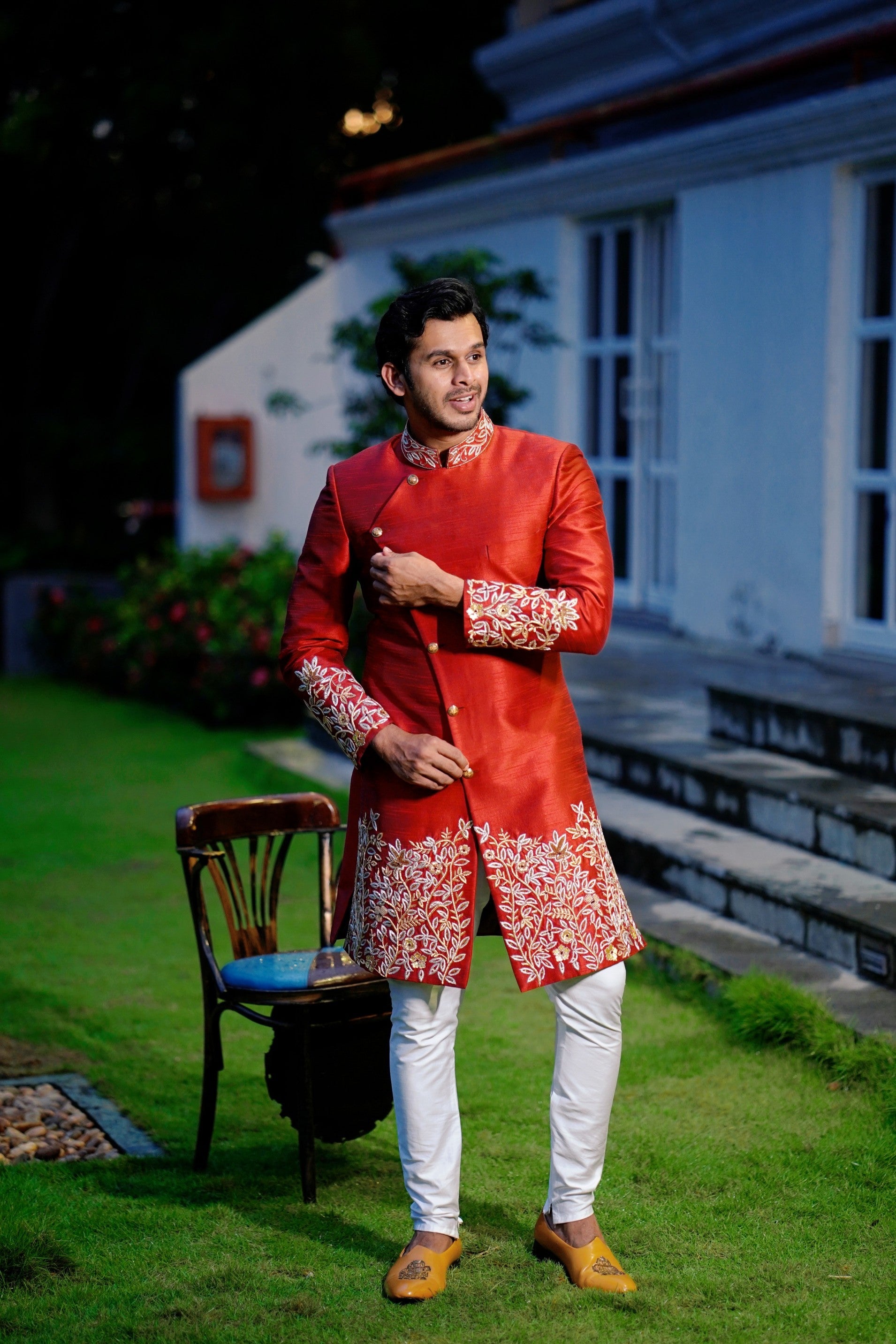Ruby Red Side Open Indo Western Slim Achkan Suit with Golden Floral Handwork Detailing paired with White Narrow Pants