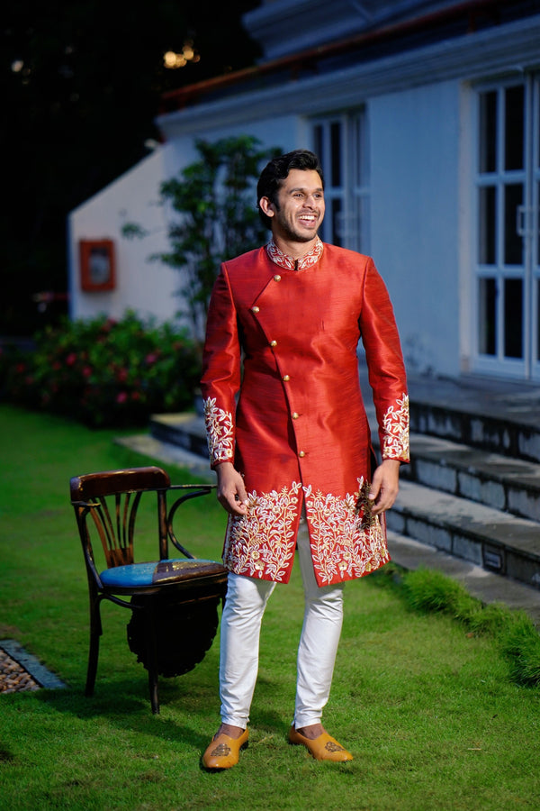 Ruby Red Side Open Indo Western Slim Achkan Suit with Golden Floral Handwork Detailing  paired with White Narrow Pants